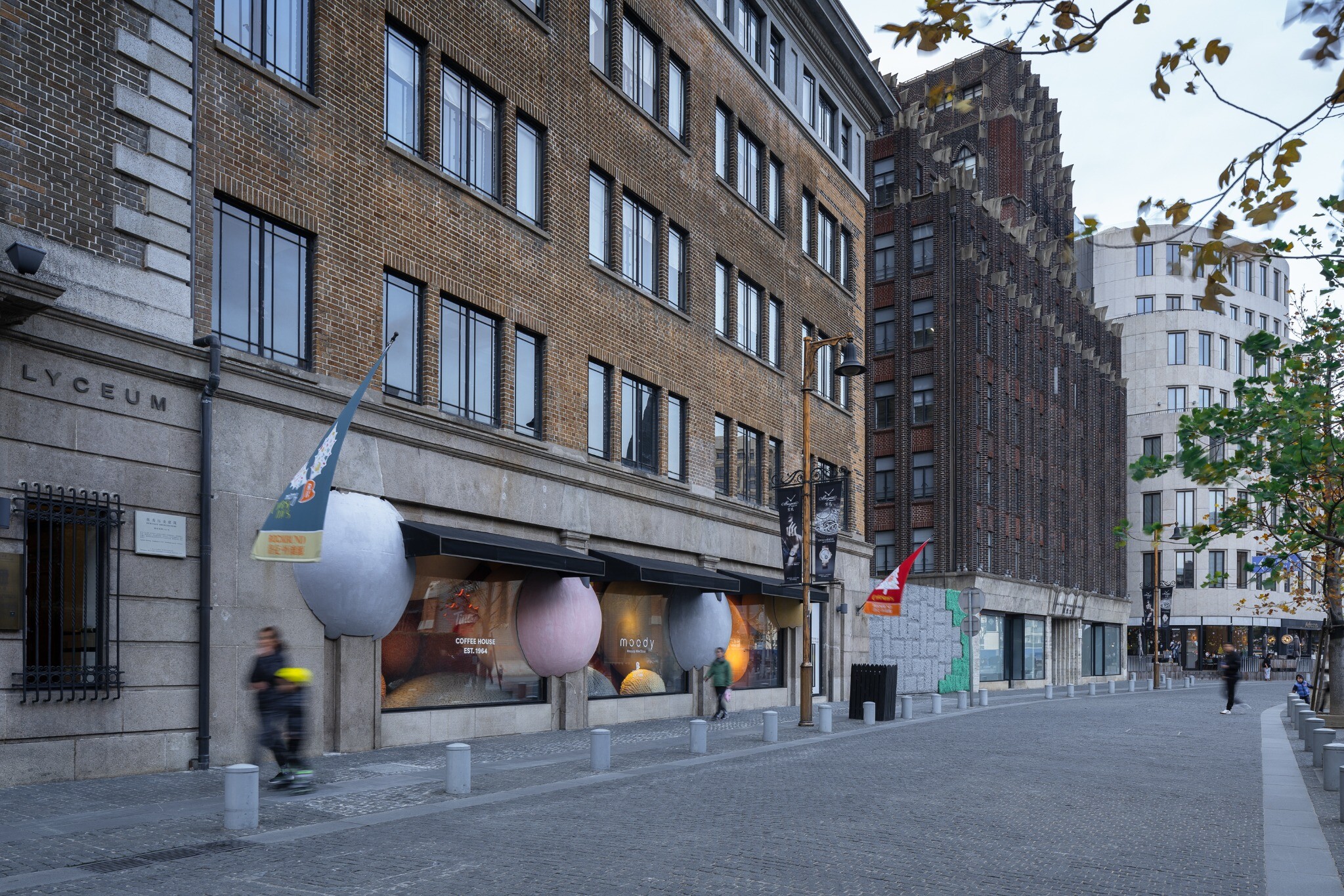 Street view outside the Lyceum Building in Rockbund, Shanghai, showing the oversized yarn balls in relation to the historic facade.