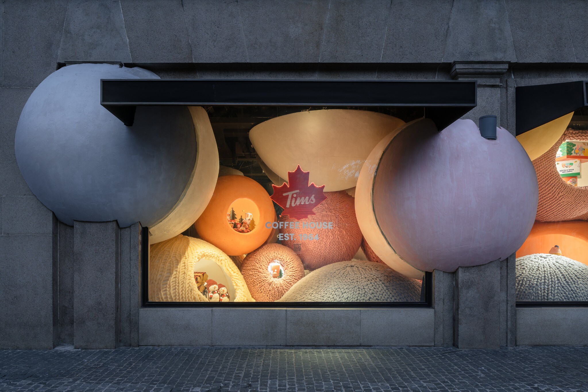 Left-side Tim Horton’s Christmas window, where a hollow floating yarn ball is used as a product display space.