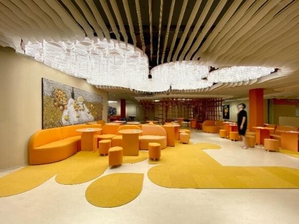 Children’s activity and reading space composed of orange furniture and wood-toned bookshelves.