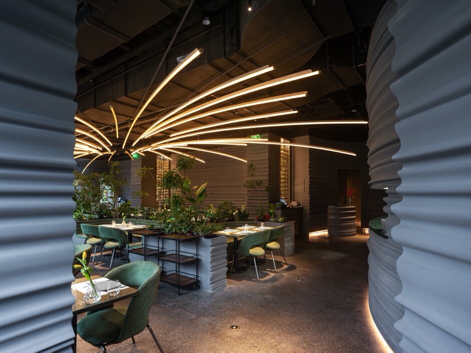 Private room extending the sculptural line language through wall surfaces, banquette seating, and lighting.