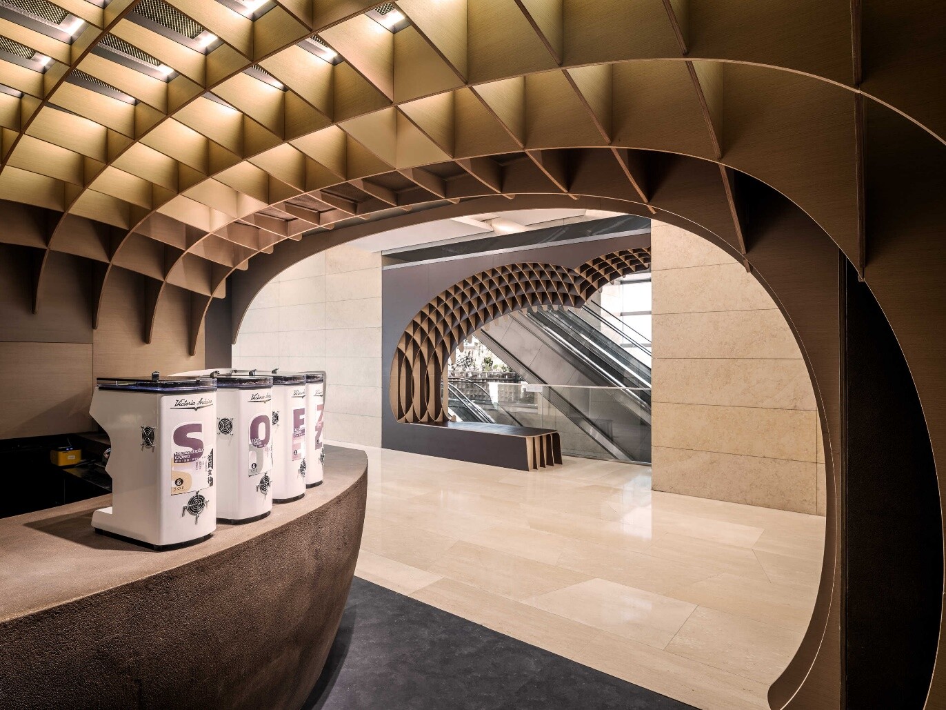 White coffee zone facing the corridor, where light-colored structure and coffee-bean curves strengthen visual extension.