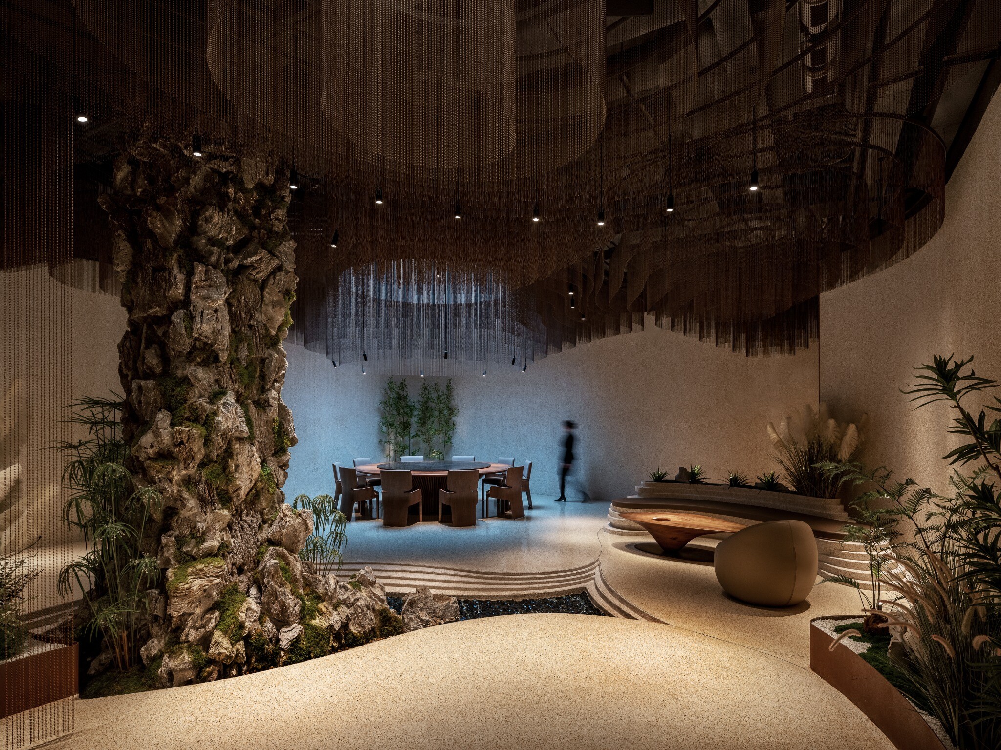 View from the performance area toward the private dining area, showing the relationship among stage, stone landscape, and dining space.