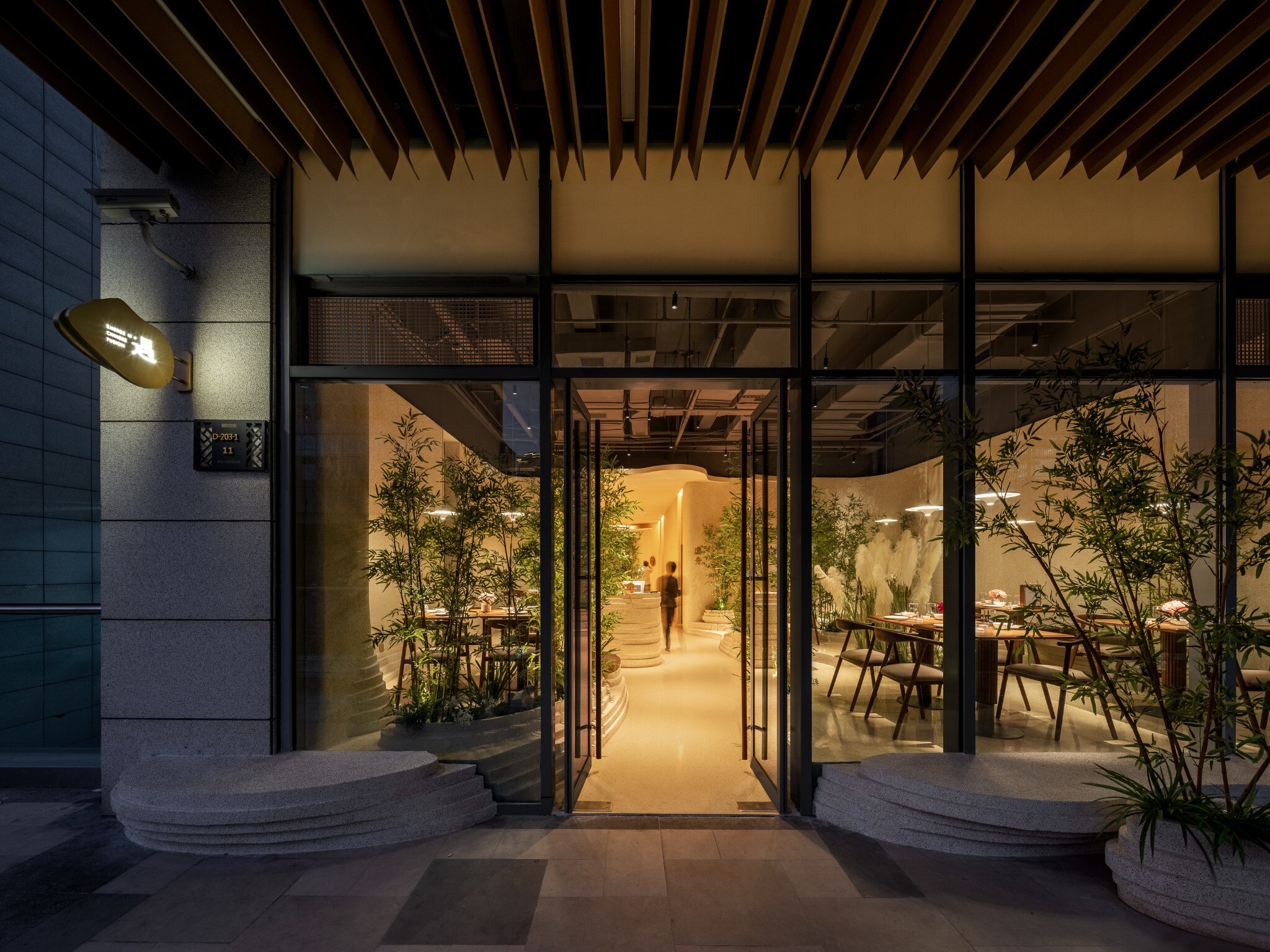 View from the second-floor outdoor corridor toward the restaurant, showing the relationship between the lakeside restaurant and exterior circulation.