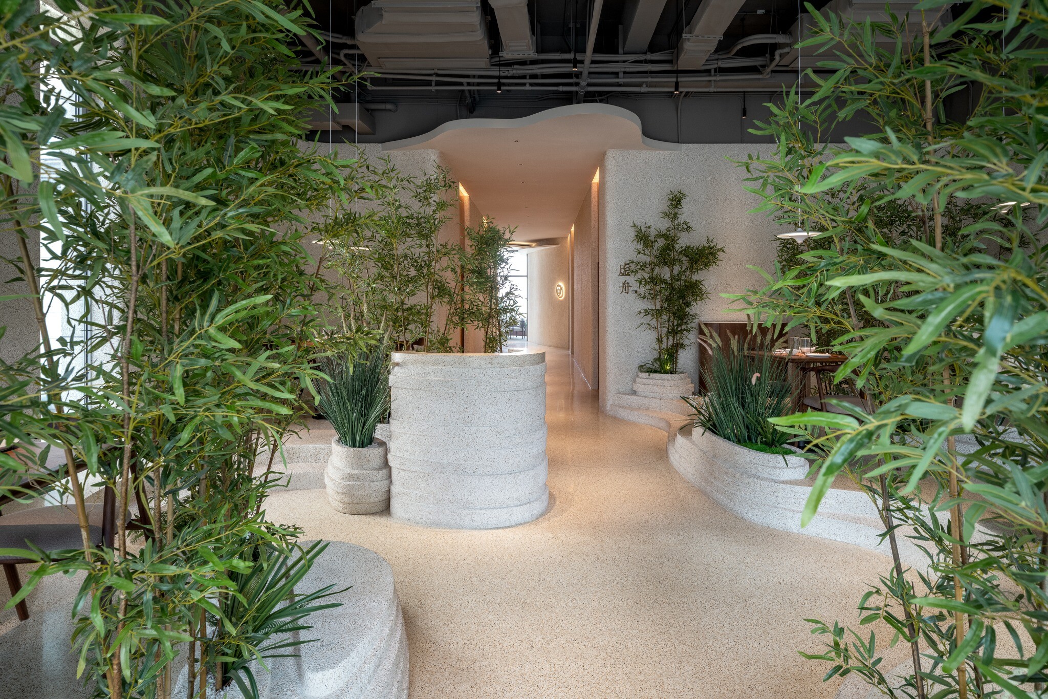 Curved end corridor of YiXing YU Restaurant, blocking direct views and guiding guests toward the second-floor private rooms.